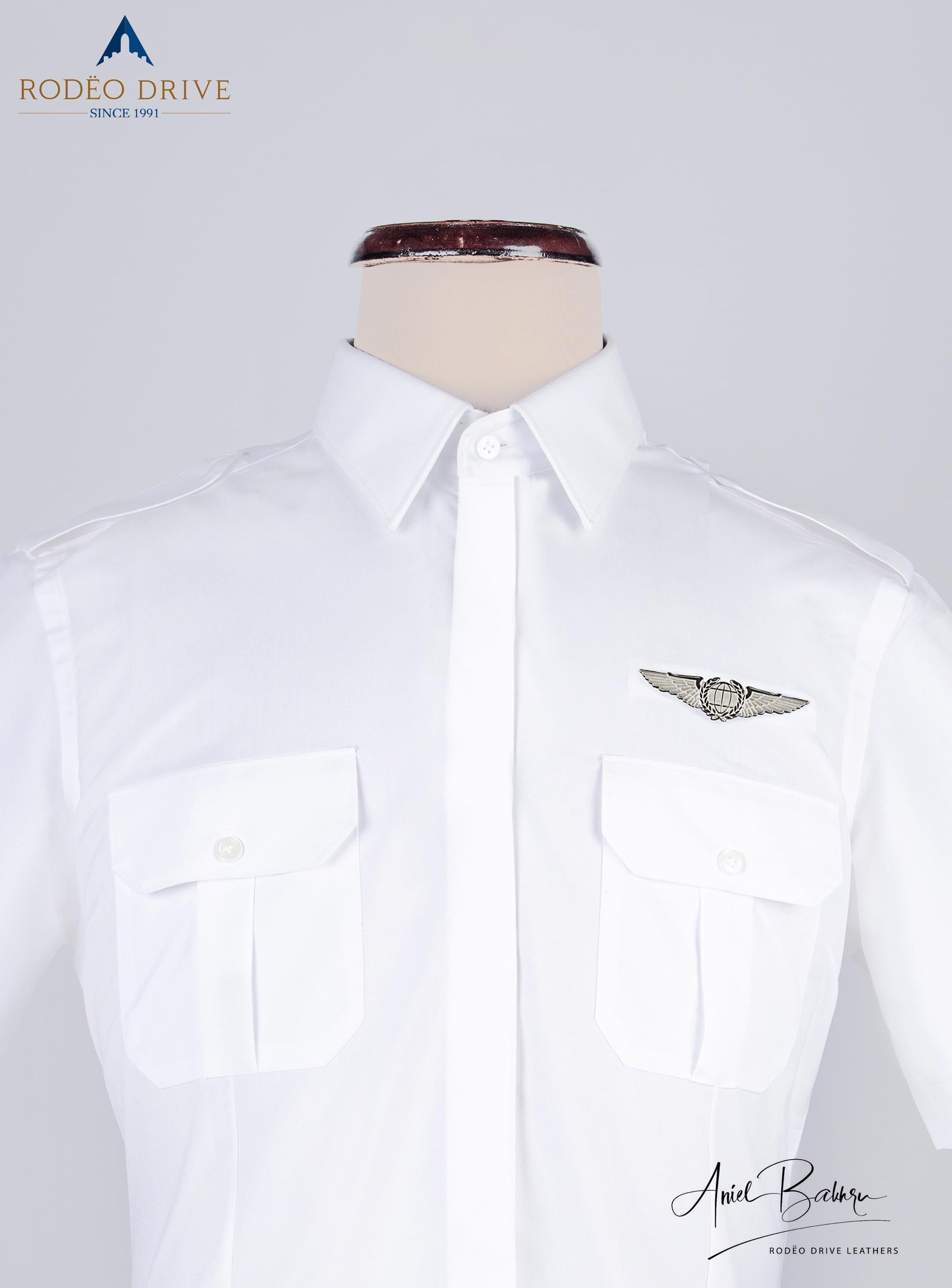 close front image of white Women's Pilot shirt. Two pockets with buttoned strap are visible.  The  shirt is buttoned and displayed on mannequin