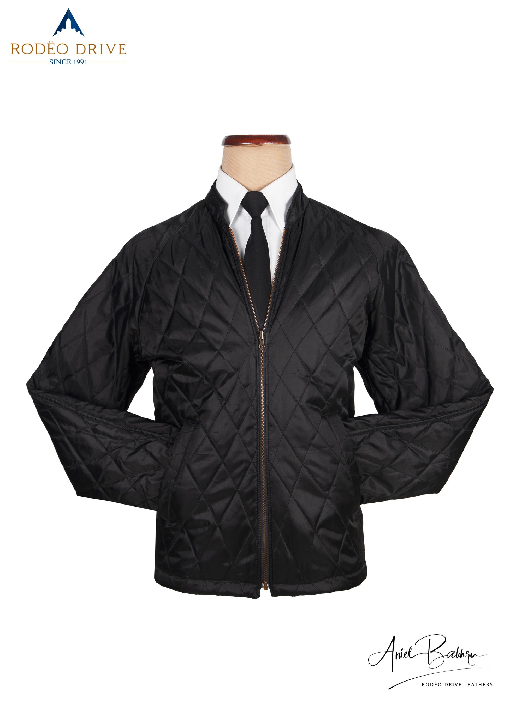 Front image of Black leather jacket. It is displayed on mannequin. It is zipped. A white shirt and neck tie is tucked in. A classic way to wear the jacket