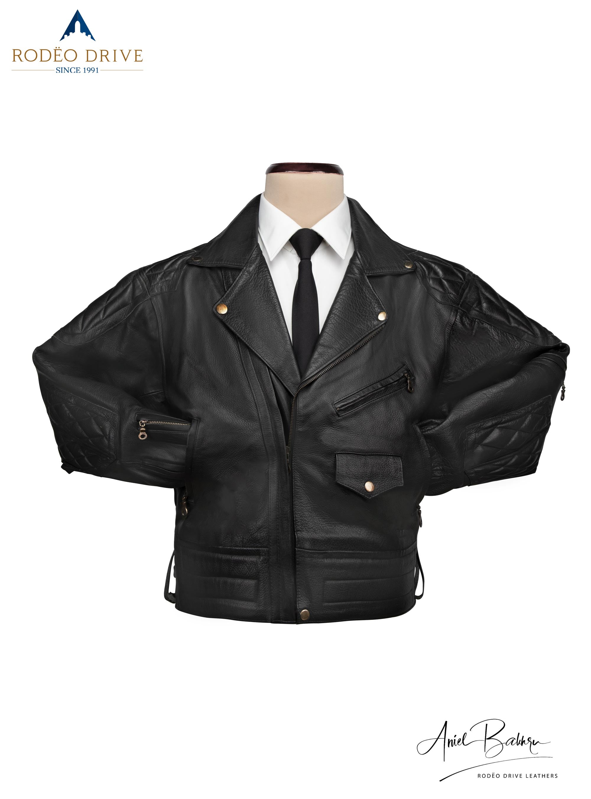 Front image of black WEAZEL BIKER JACKET.. It is displayed on mannequin. a white shirt is tucked in with a black neck tie. Both its hand are tucked inside slit pockets. It is half zipped