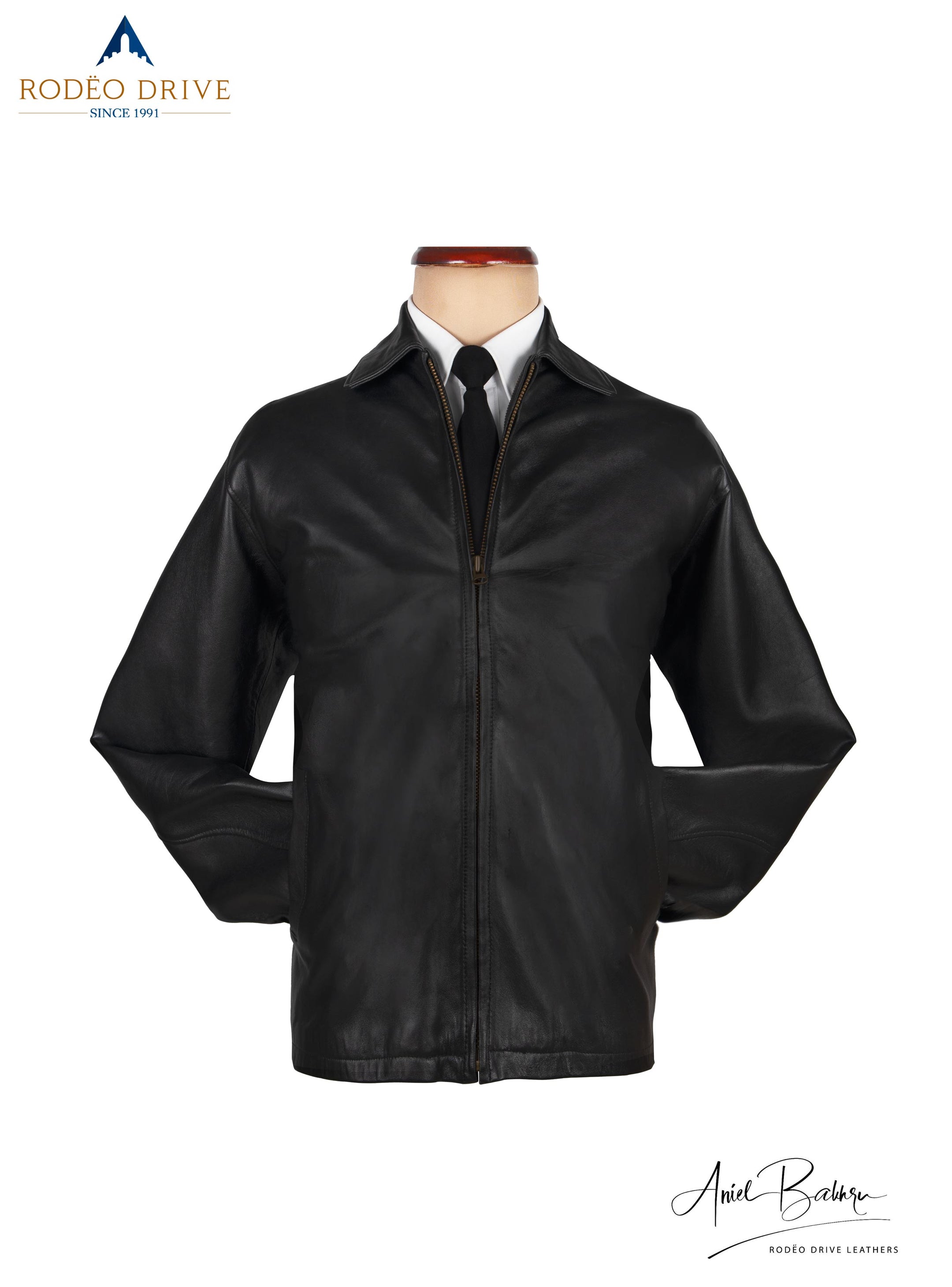 Front image of Black leather jacket. It is displayed on mannequin. It is zipped. A white shirt and neck tie is tucked in. A classic way to wear the jacket