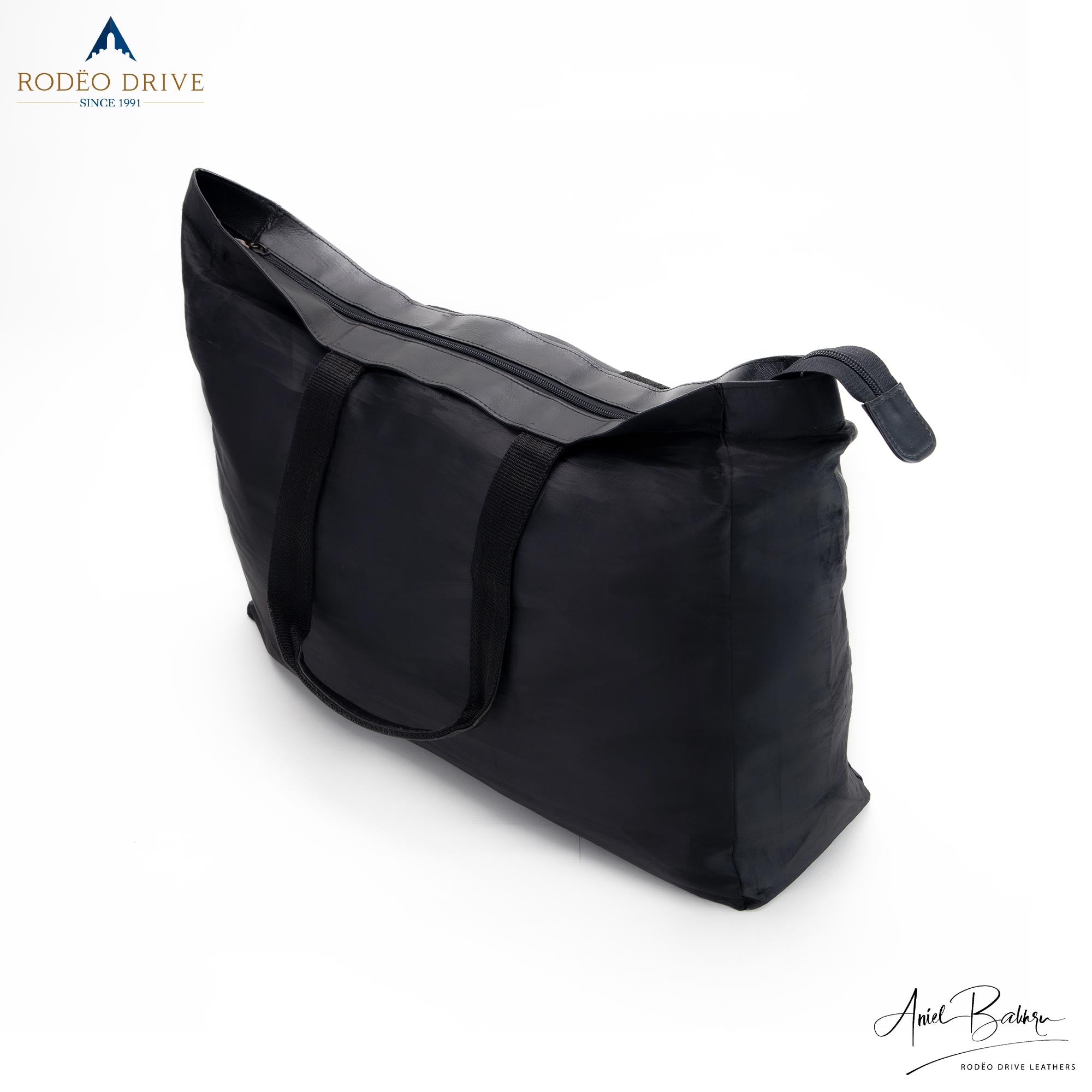 Side image of  black KELLY LEATHER SHOPPING BAG. Top of it is zipped.