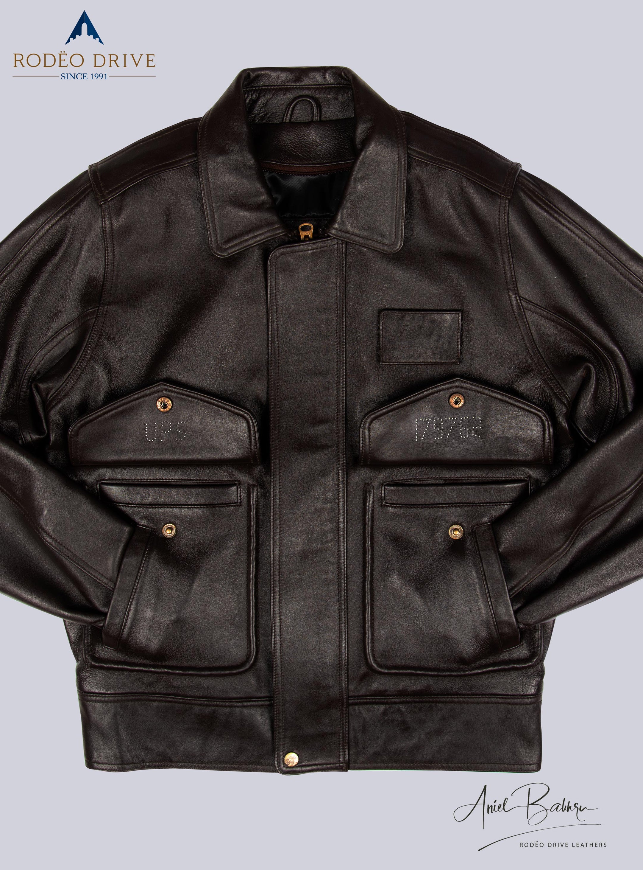 Front image of brown LEATHER JACKET for  MEN. Hands of jacket are tucked inside slit pockets. other two pockets have buttoned straps
