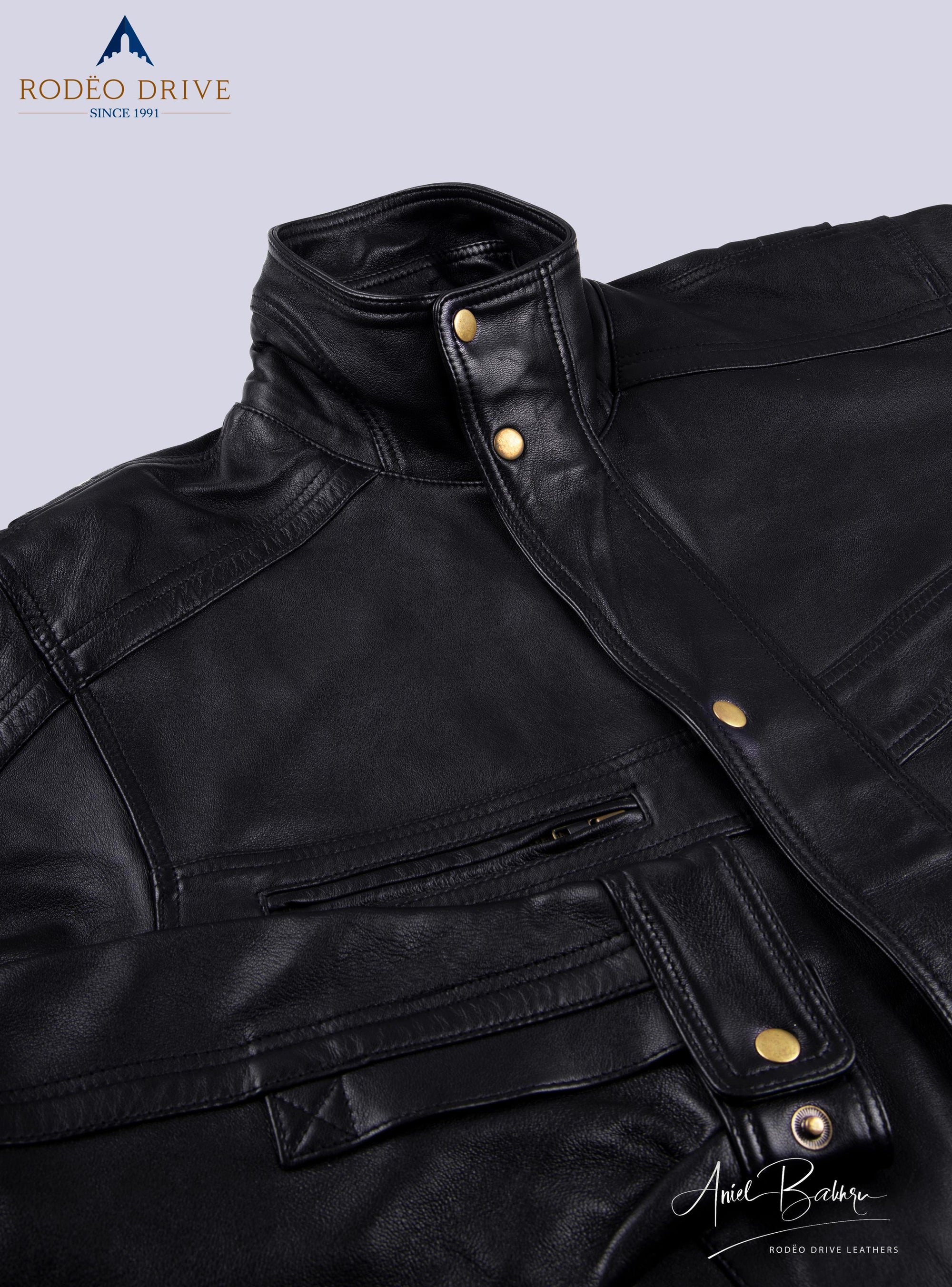 Image of right pocket of bomber jacket. Pocket is zipped . A stylish strap is  tucked just below it.